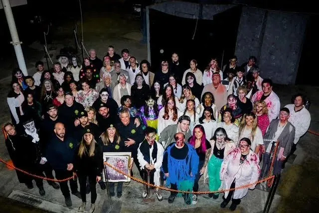 The Scared by the Sound cast and crew in costume and makeup, gathered for a group photo outside the haunt.